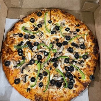 Pizza topped with black olives, mushrooms and green bell peppers in a delivery box